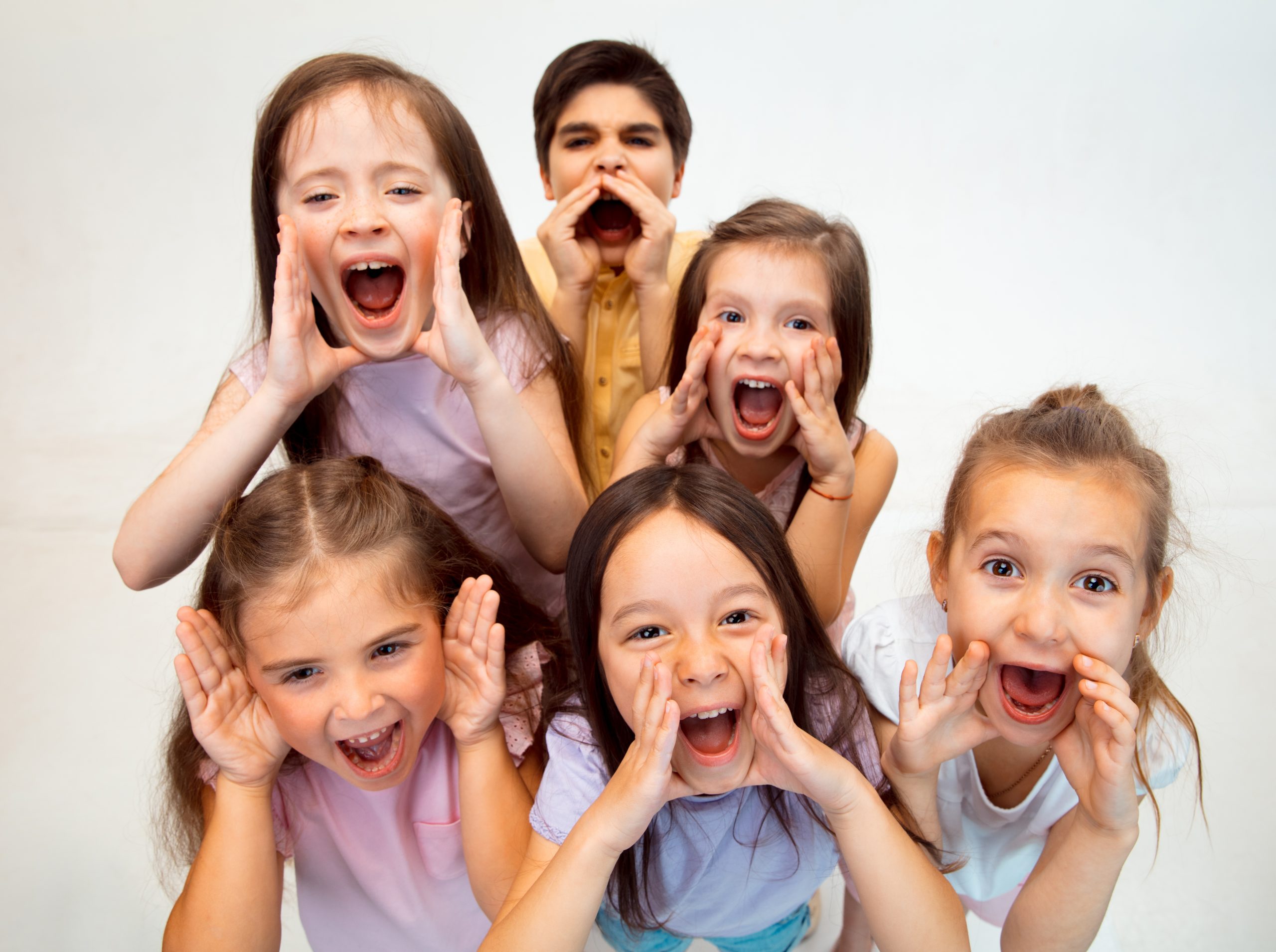 The portrait of cute little boy and girls in stylish clothes looking at camera at studio